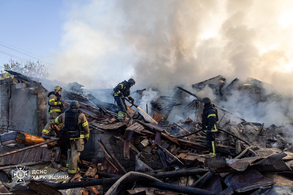 Firefighters work at the site of a private household hit during morning Russian drone strikes in Kharkiv (Reuters)