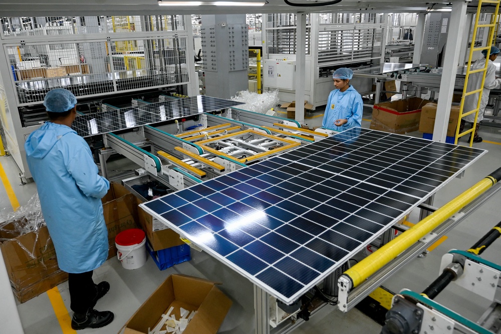 File. Factory workers inspect solar panels at an Adani Group facility in Gujarat, India (AFP/Getty)