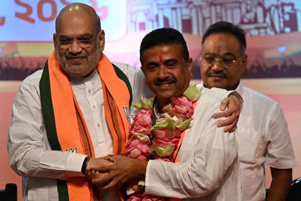 India's home minister Amit Shah (L) greets Bharatiya Janata Party (BJP) leader and newly selected chief minister of West Bengal Suvendu Adhikari (C) during a party meeting in Kolkata on 8 May 2026 (AFP/Getty)