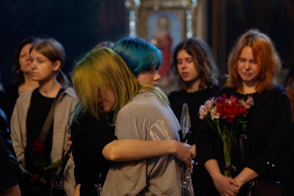 Teenagers hug during a funeral ceremony for 12-year-old and 17-year-old sisters Liubava and Vira Yakovleva, who were killed in a Russian attack that killed 24 people on May 14, during a funeral ceremony at the Saint Michael's Golden-Domed Monastery in Kyiv on May 19, 2026, amid the Russian invasion of Ukraine (AFP/Getty)