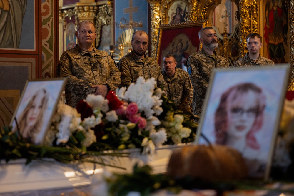 Ukrainian service men mourn at the coffins of 12-year-old and 17-year-old sisters Liubava and Vira Yakovleva, who were killed in a Russian attack that killed 24 people on May 14, during a funeral ceremony at the Saint Michael's Golden-Domed Monastery in Kyiv on May 19, 2026, amid the Russian invasion of Ukraine. (AFP/Getty)
