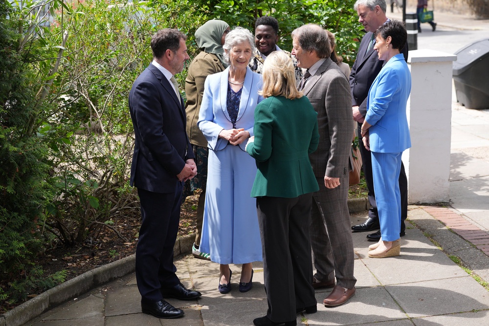 Ms Connolly, second left, was greeted at the community centre by chief executive Seamus MacCormaic, left (Yui Mok/PA) (PA Wire)