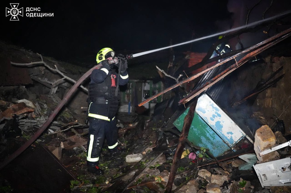 A rescue worker puts out a fire of a building damaged after a Russian strike on Odesa (AP)