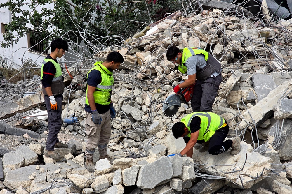 Lebanese civil defence workers search through the rubble in the southern Lebanese village of Deir Qanun al-Nahr on May 20, 2026, a day after Israeli strikes. (AFP/Getty)