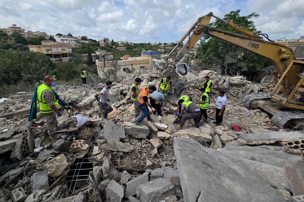 Lebanese civil defence workers search through the rubble in the southern Lebanese village of Deir Qanun al-Nahr on May 20, 2026, a day after Israeli strikes. (AFP/Getty)