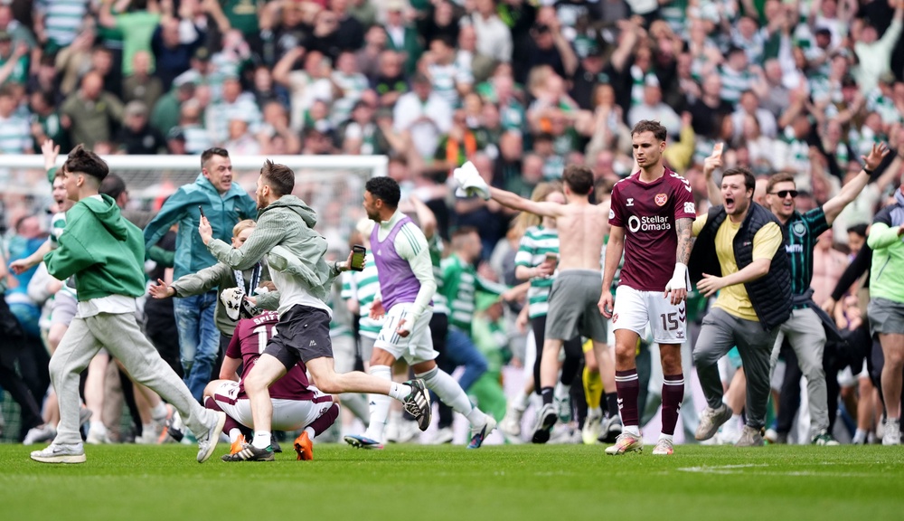Celtic fans invaded the pitch after their team's third goal against Hearts (PA)