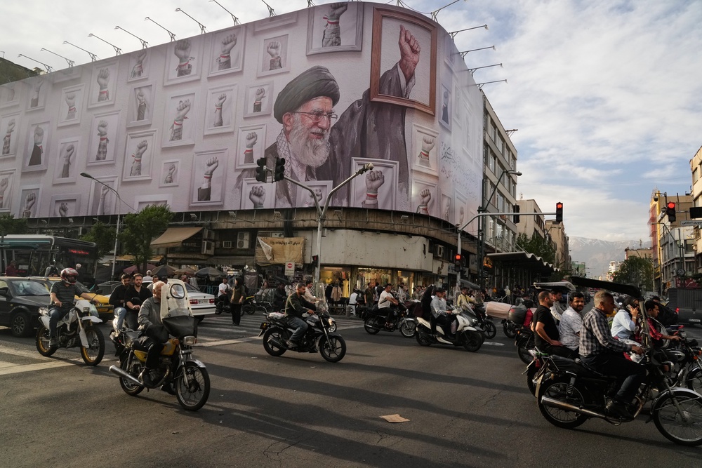 Motorbikes drive past a billboard showing the late Iranian Supreme Leader Ayatollah Ali Khamenei, who was killed in the U.S. and Israel strikes on Feb. 28, in downtown Tehran, Iran, May 6, 2026. (AP Photo/Vahid Salemi, File) (AP)