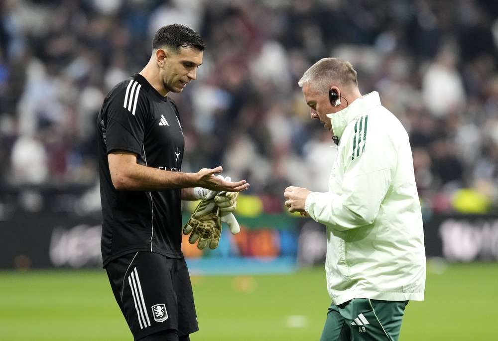 Emiliano Martinez (left) receives treatment for a broken finger (Nick Potts/PA) (PA Wire)