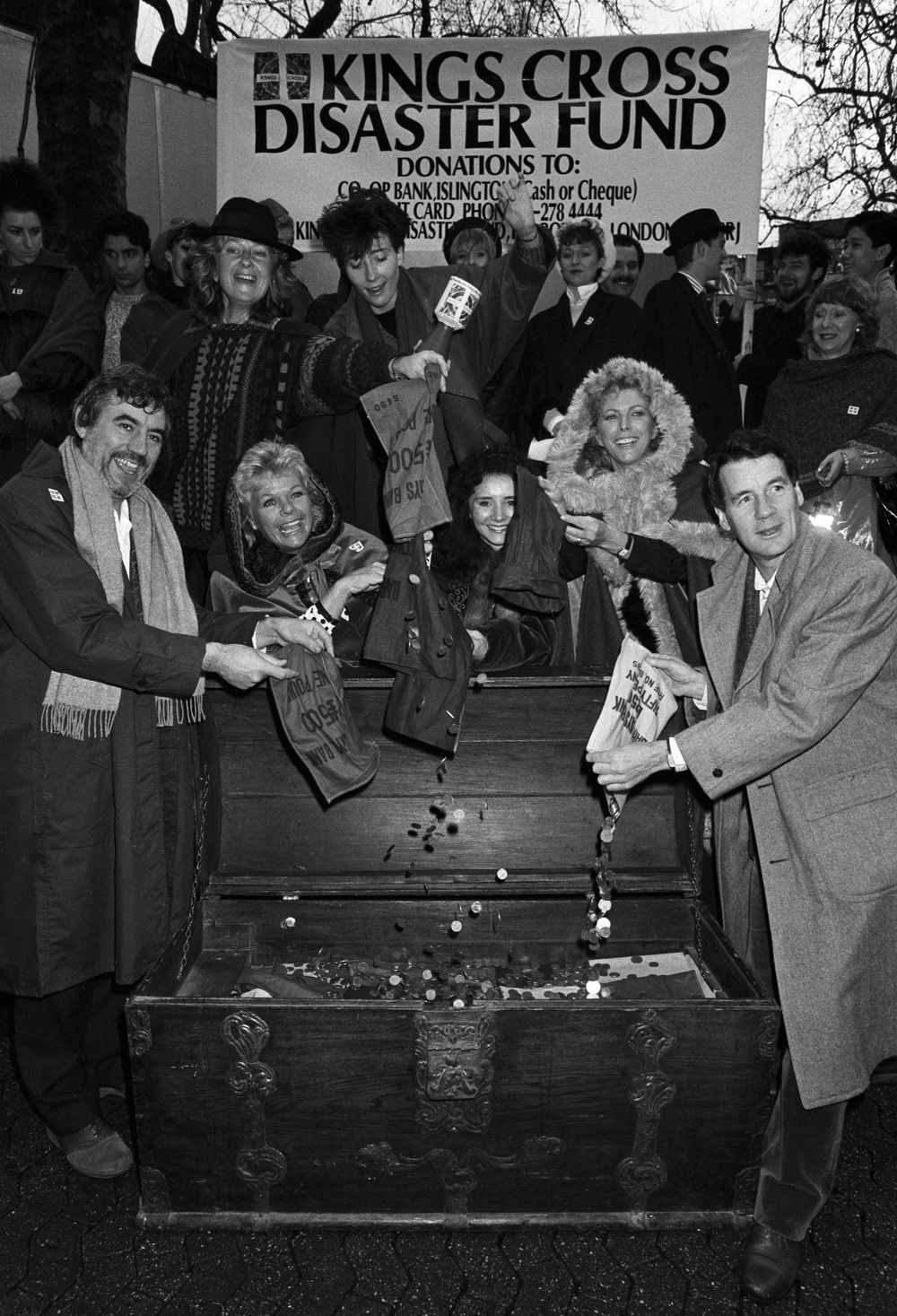 Showbusiness stars helping to fill the coffers of the King’s Cross Disaster Fund appeal at a carol singing session in Leicester Square, London. (Front, L-R) Terry Jones, Judith Chalmers, Sarah Pickering, Billie Whitelaw and Michael Palin. Behind is TV actresses Anna Carteret (with brimmed hat) empties her bag and Emma Thompson holds a collecting box (centre), while in the background are the cast of Kiss Me Kate (PA) (PA Archive)