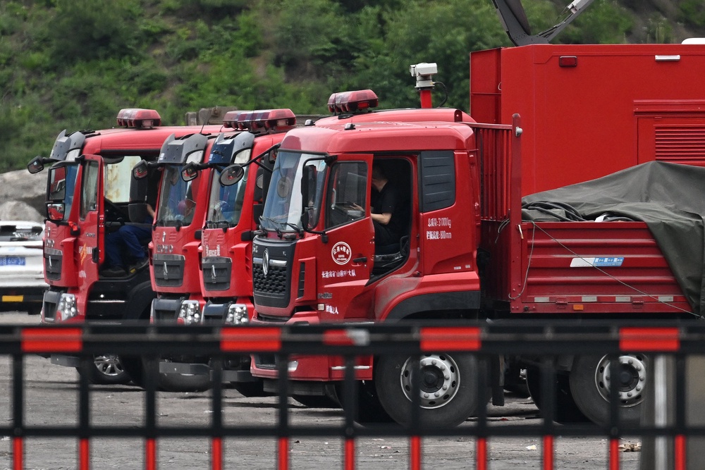 Drivers wait in rescue vehicles outside the Liushenyu coal mine, where an explosion killed dozens in Qinyuan county, in China's northern Shanxi province on 24 May 2026 (AFP/Getty)