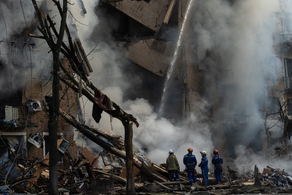 Rescuers operate at the site of a heavily damaged building as smoke rises following Russian strikes in Kyiv (AFP/Getty)