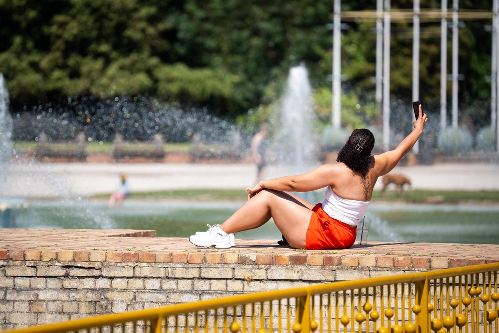 A person sunbathes near water fountains in Battersea Park, southwest London (PA)