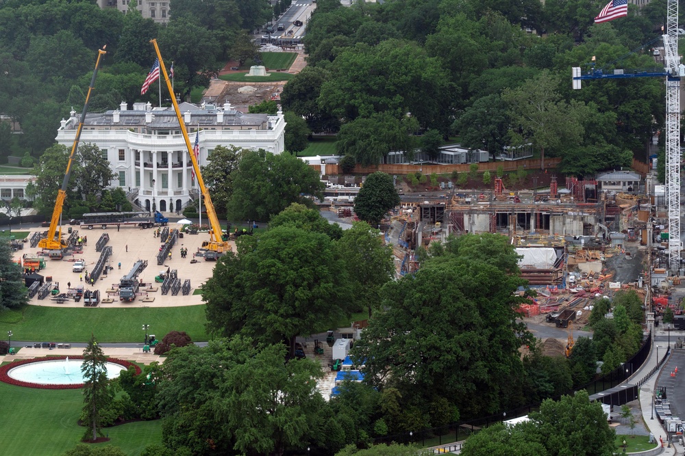 Two massive yellow cranes were seen towering over the South Lawn as pieces of the rig lay on the ground below, one photo taken Saturday appears to show (AP)