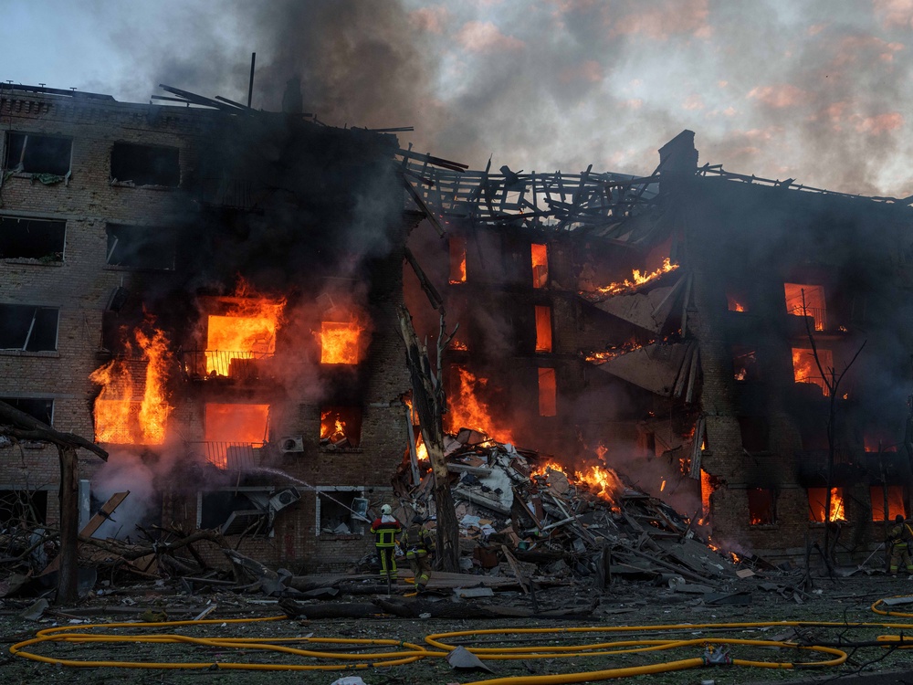 Rescue workers try to put out a fire at a residential building after a Russian strike on Kyiv. (AP Photo/Evgeniy Maloletka)