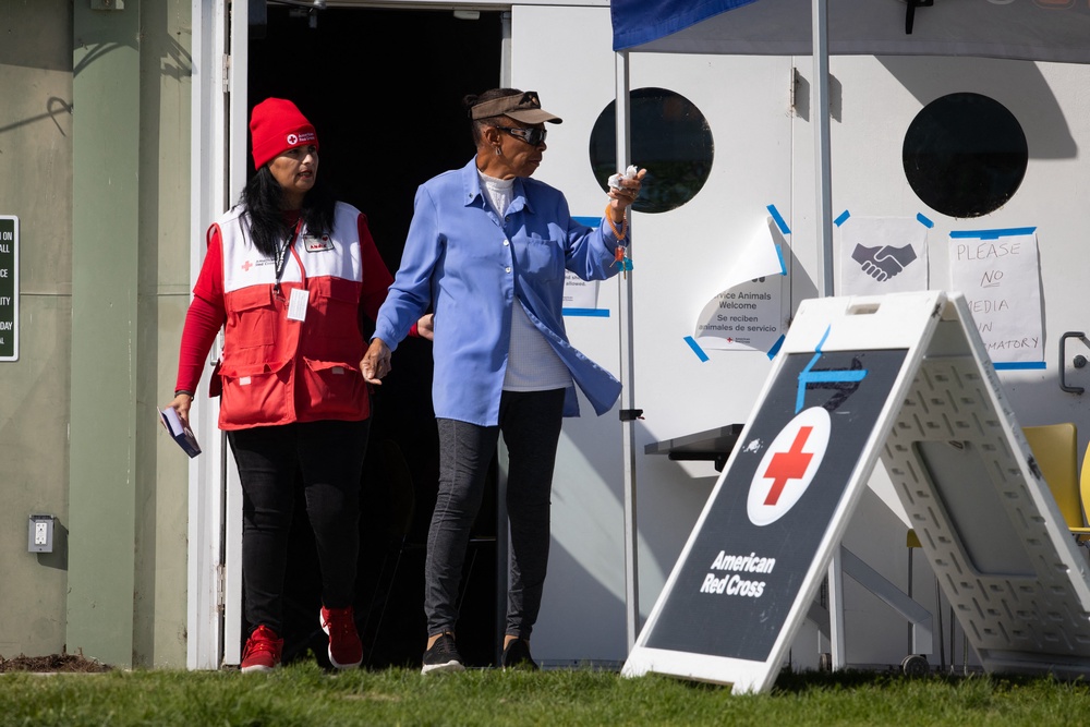 An American Red Cross member walks with an evacuee at a shelter in Fountain Valley, California, (AFP/Getty)