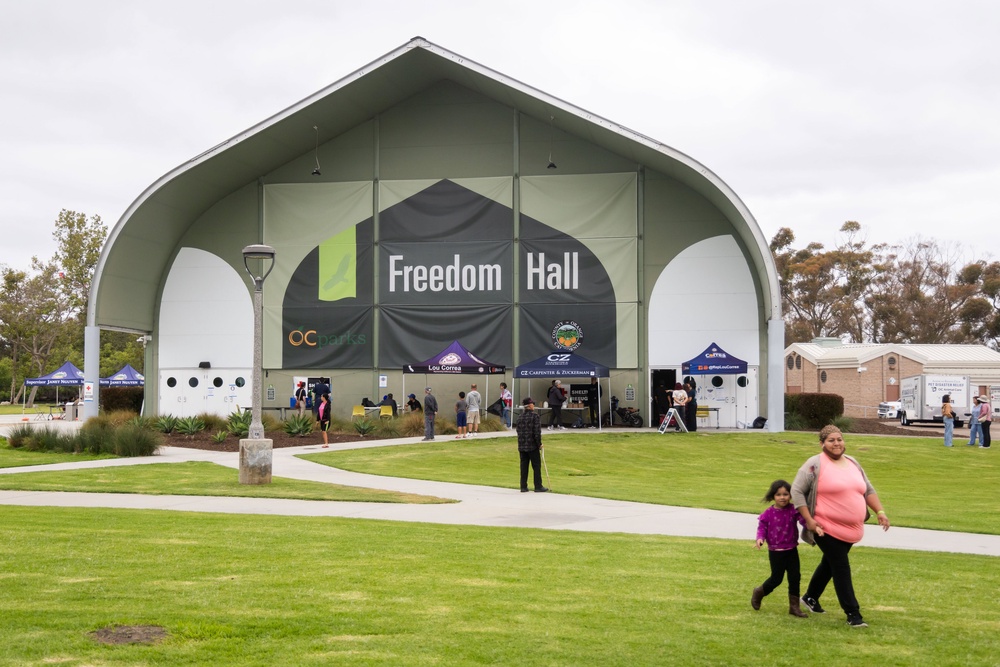 People walk outside Freedom Hall, an evacuation center in Fountain Valley, California (AP)