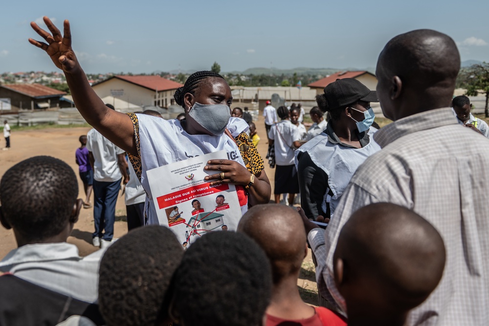 Vanny Birungi, a Red Cross volunteer, speaks to people during a public sensitisation campaign amid the Ebola outbreak in Bunia, Congo, (AP)