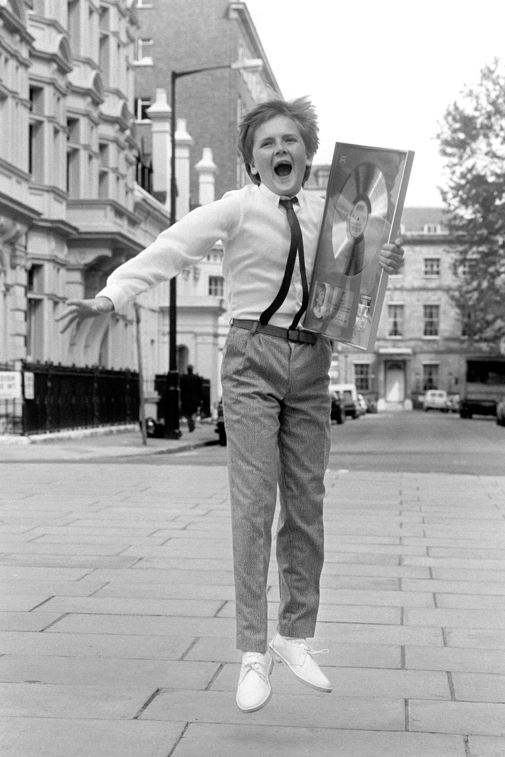 Aled Jones, aged 14, jumping for joy after collecting a silver disc for the best-selling album 'Voices from the Holy Land' (PA)