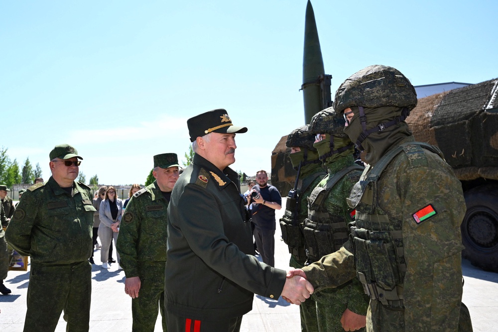 Belarusian President Alexander Lukashenko shakes hands with a service member next to the Iskander-M missile launcher as he visits a missile brigade of the Armed Forces during joint Russian-Belarusian nuclear exercises. (Reuters)