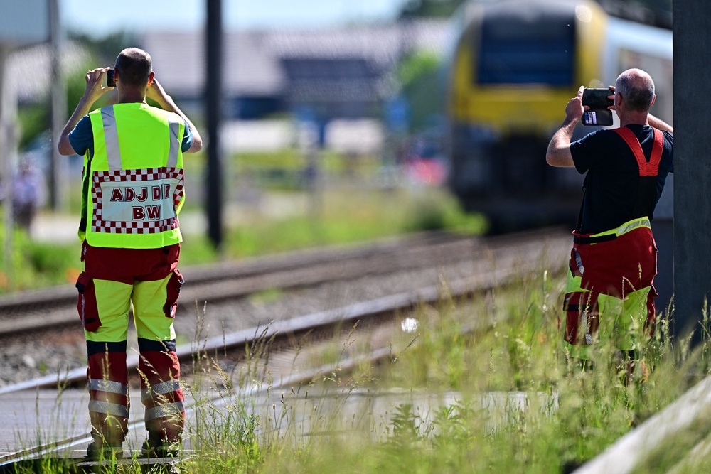 Emergency services take images with their smartphones at the site of an accident after a train crashed into a school bus, at the railway crossing Vierhuizen in Buggenhout (AFP/Getty)