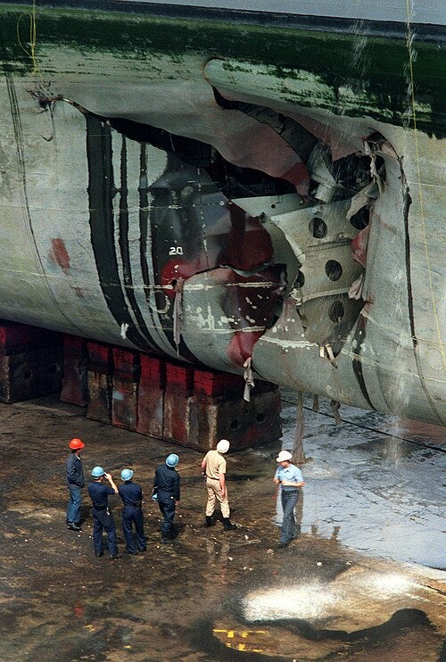 Repair crews inspect the hold that was ripped open in the hull of the amphibious assault ship USS Tripoli when the ship struck an Iraqi mine in February 1991 (US Navy)