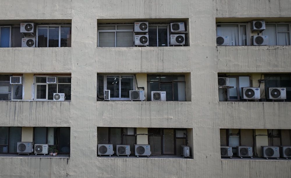 Air conditioning outdoor units are seen mounted on the exterior of a multi-storey building (Getty)