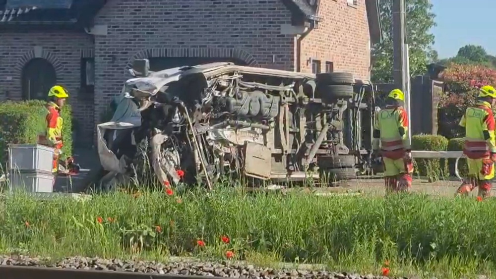 This video grab shows rescue workers on the scene of a crash between a train and vehicle in Buggenhout (AP)