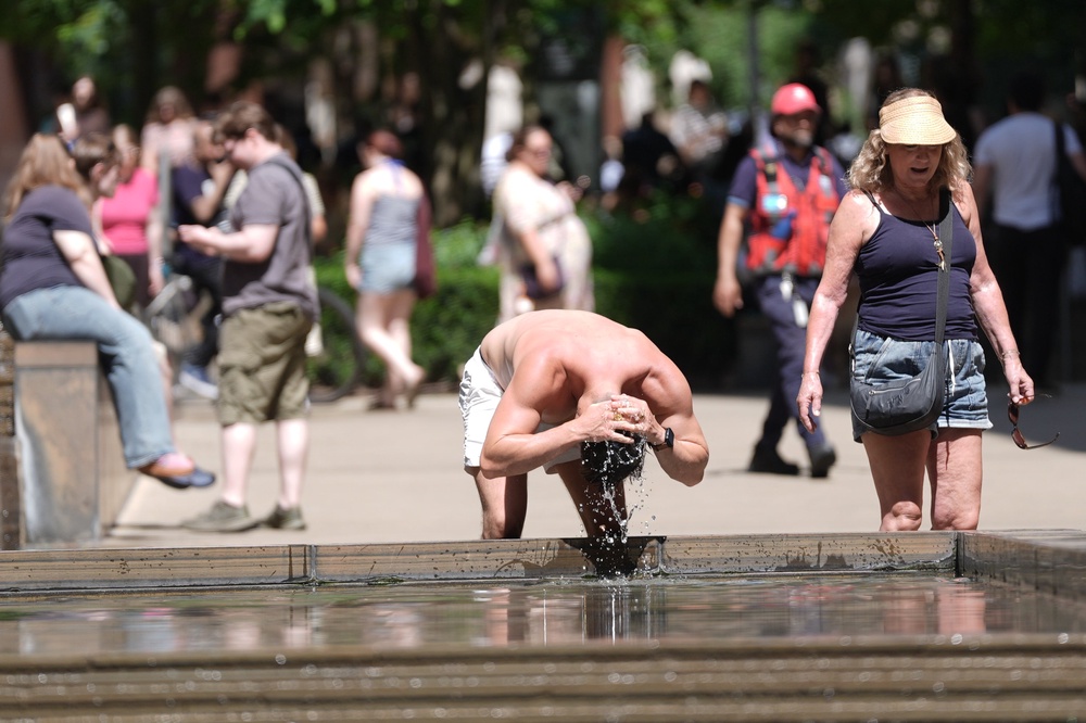 A man tries to cool down in the hot weather in London's King's Cross (PA)