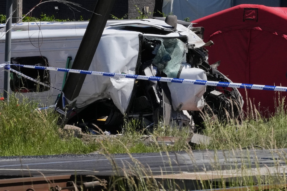 Police tape cordons off a level crossing where a train collided with a van (AP)