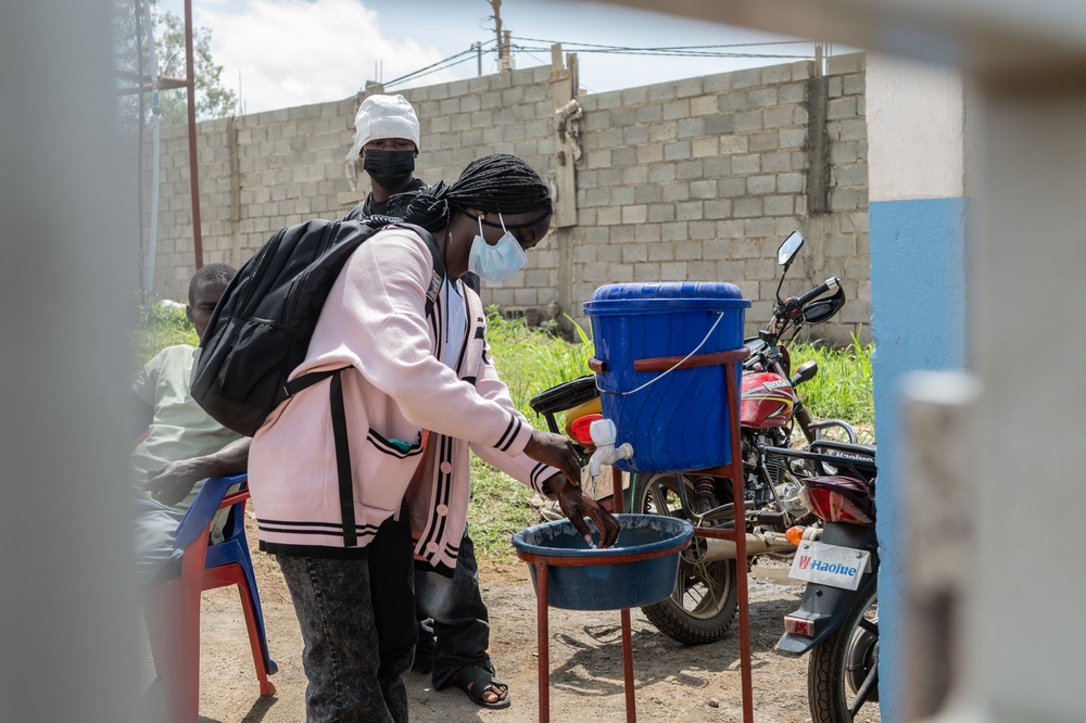 A young woman washes her hands before entering Bunia General Hospital (Moses Sawasawa/ActionAid)