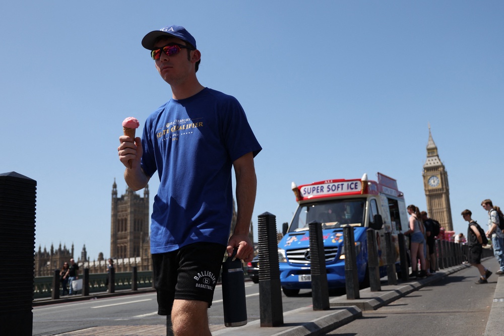 Tourists walk across Westminster bridge buying and eating ice cream (AFP/Getty)