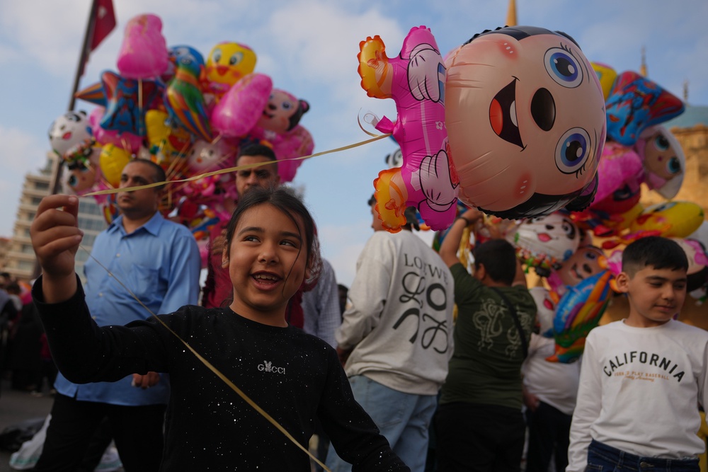 A girl holds a balloon as she celebrates Eid al-Adha with her family after Eid prayers outside Mohammad Al-Amin Mosque in Beirut, Lebanon, Wednesday, 27 May 2026 (Associated Press)