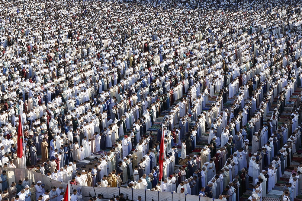 Muslim worshippers perform morning prayers marking the start of Eid al-Adha, the Feast of Sacrifice, in open-air prayer grounds in Salé on 27 May 2026 (AFP/Getty)