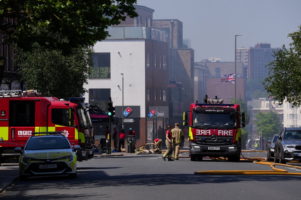 Firefighters work at the scene of a fire started behind a Jewish supermarket (Reuters)