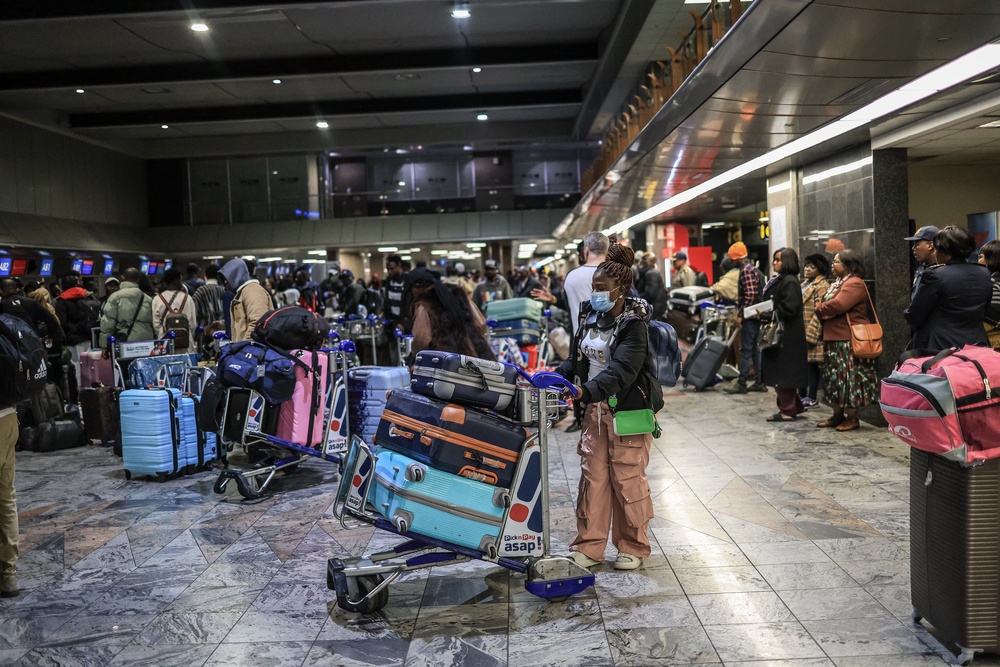 Ghanaian nationals stand at the check-in desk for an evacuation flight at OR Tambo International Airport in Ekurhuleni (AFP/Getty)