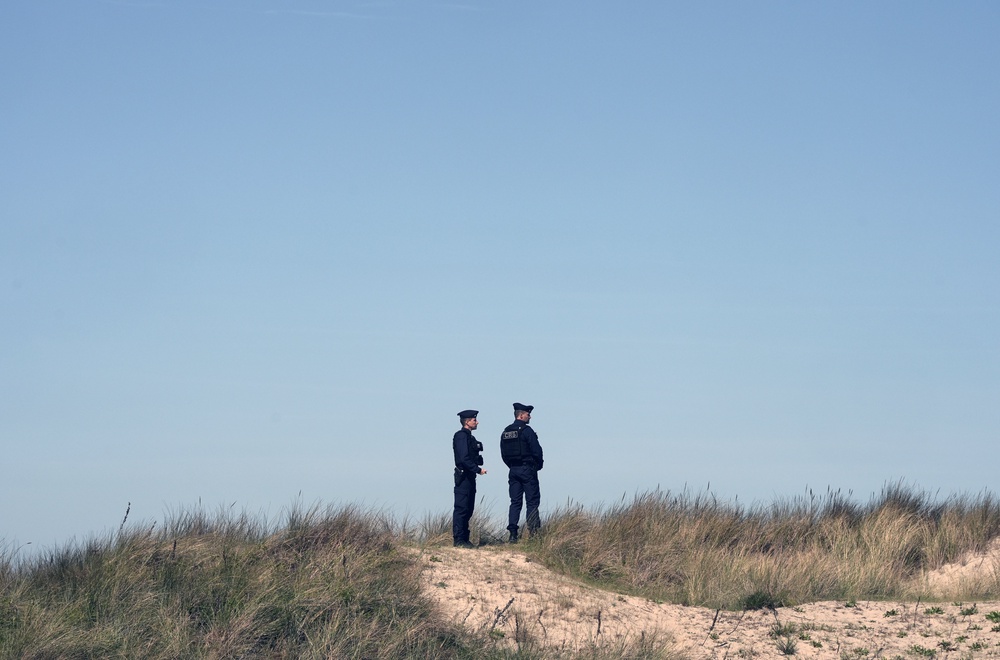 Police look out at a beach (Stefan Rousseau/PA) (PA Wire)