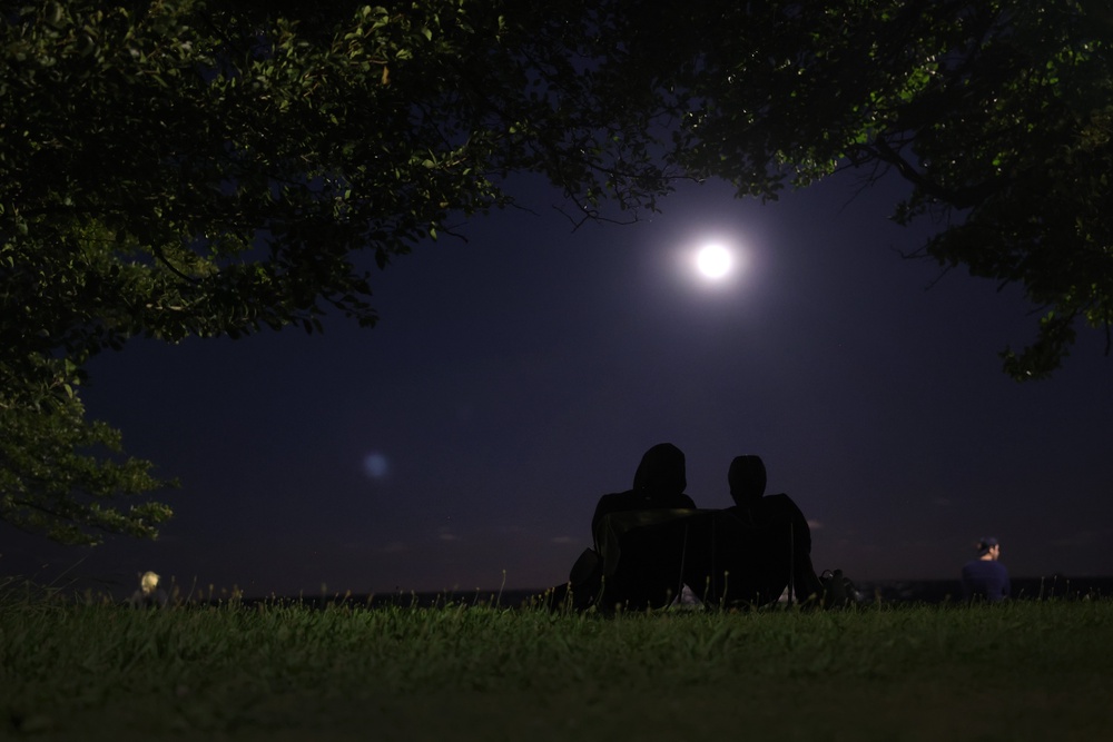 Two people watch the August 2023 blue moon rise in Chicago, Illinois. People should avoid light pollution for the clearest view of the night sky (Getty Images)