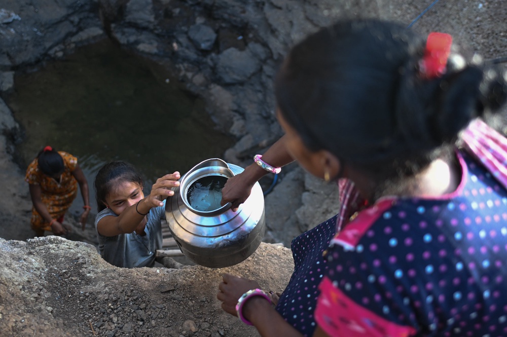 Women collect water from the partially dried remains of a well in a drought affected village on May 27, 2026 in Kaprada taluka of Valsad district, Gujarat, India (Getty)
