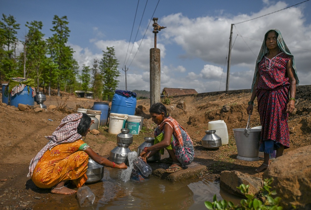 Women collect water from a stagnant and polluted source in a drought affected village in Kaprada, Gujarat, on 27 May 2026 (Getty)