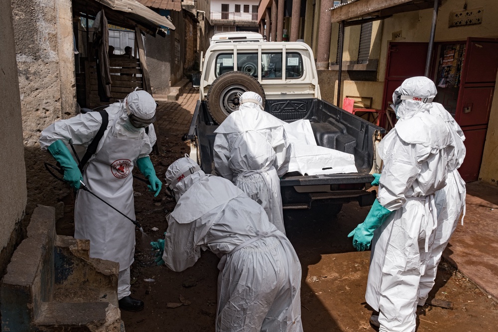 Workers from the Uganda Red Cross Society disinfect during the evacuation of the body of a suspected Ebola victim in Kampala. (AFP/Getty)