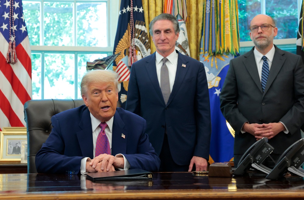 Budget director and Project 2025 co-author Russell Vought (right) and Interior Secretary Doug Burgum stand behind President Donald Trump in the Oval Office of the White House (Getty)