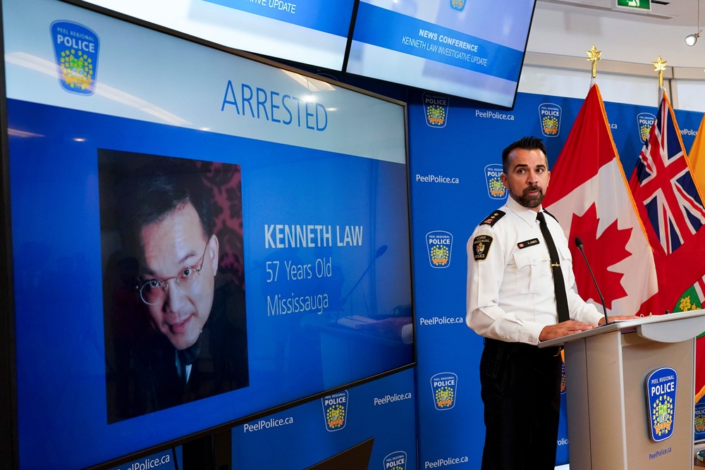 York Regional Police Inspector Simon James speaks during a news conference in Mississauga, Ont., Aug. 29, 2023, with the image of Kenneth Law (The Canadian Press)