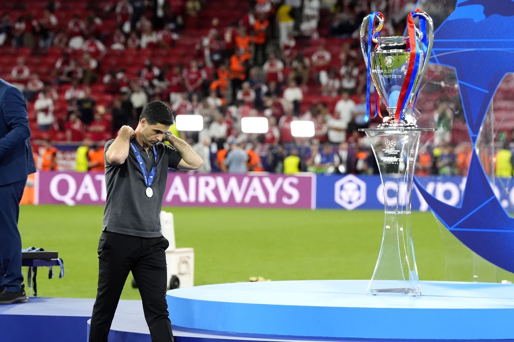 Arsenal manager Mikel Arteta walks past the trophy following defeat (PA)