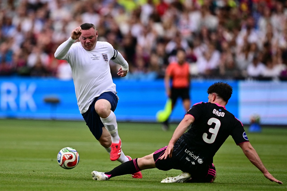 Wayne Rooney is tackled by British actor Richard Gadd (AFP/Getty)