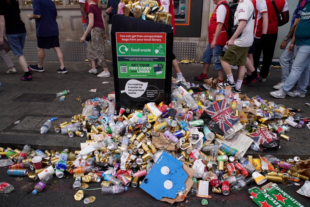 Arsenal fans walk past an overflowing litter bin as they make their way home following the parade (Gareth Fuller/PA) (PA Wire)