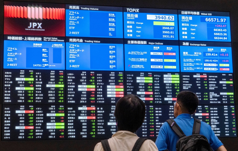 Visitors look at electronic display boards showing stock prices and economic indicators at the Tokyo Stock Exchange in Tokyo (AFP/Getty)