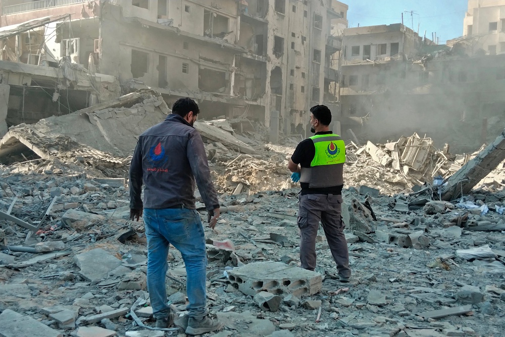 Civil defence workers inspect the site of an Israeli strike in the southern Lebanese city of Tyre on 31 May (AFP/Getty)