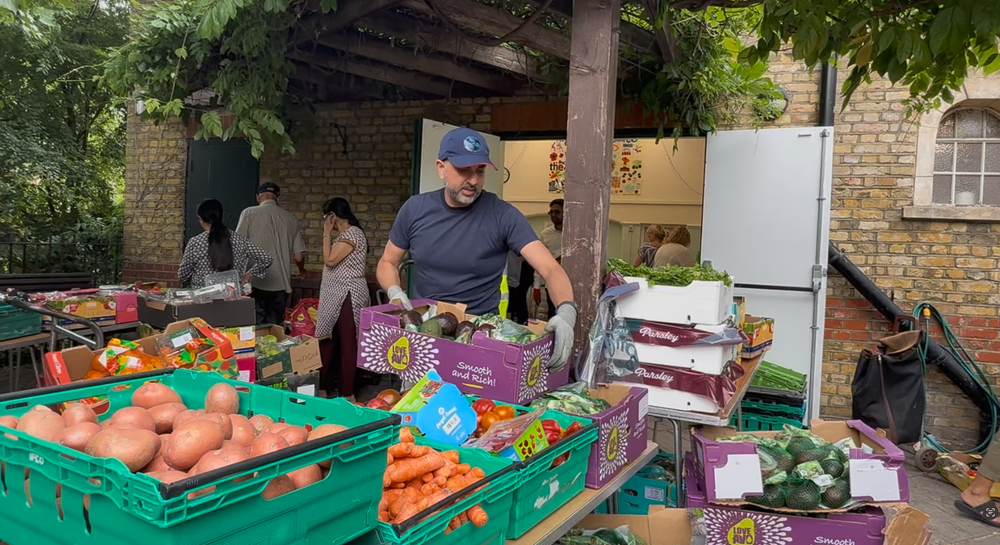 Khalil Mohammed, volunteer at Rotherhithe Community Kitchen, helps set up the food bank (The Independent)