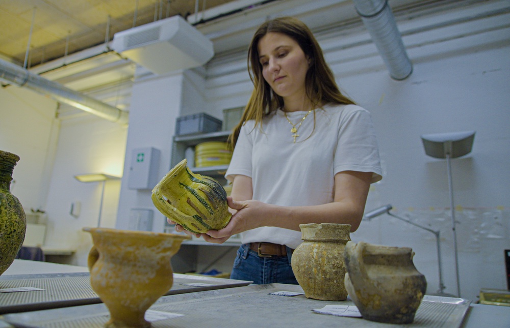 Archaeologist Valentine Breloux holds ceramic fragments discovered during the excavations (AP/Nicolas Garriga)