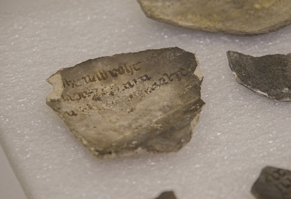 A fragment bearing an inscription is photographed among artifacts discovered during excavations outside Notre-Dame Cathedral (AP/Nicolas Garriga)